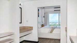 Ett modernt hotellrum med en säng, ett litet skrivbord och utsikt över staden.
