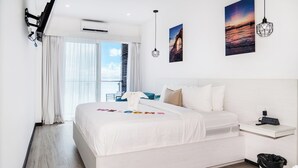 Una habitación de hotel moderna con una cama grande, una mesita de noche con un reloj, una ventana con cortinas y un aire acondicionado instalado en la pared.