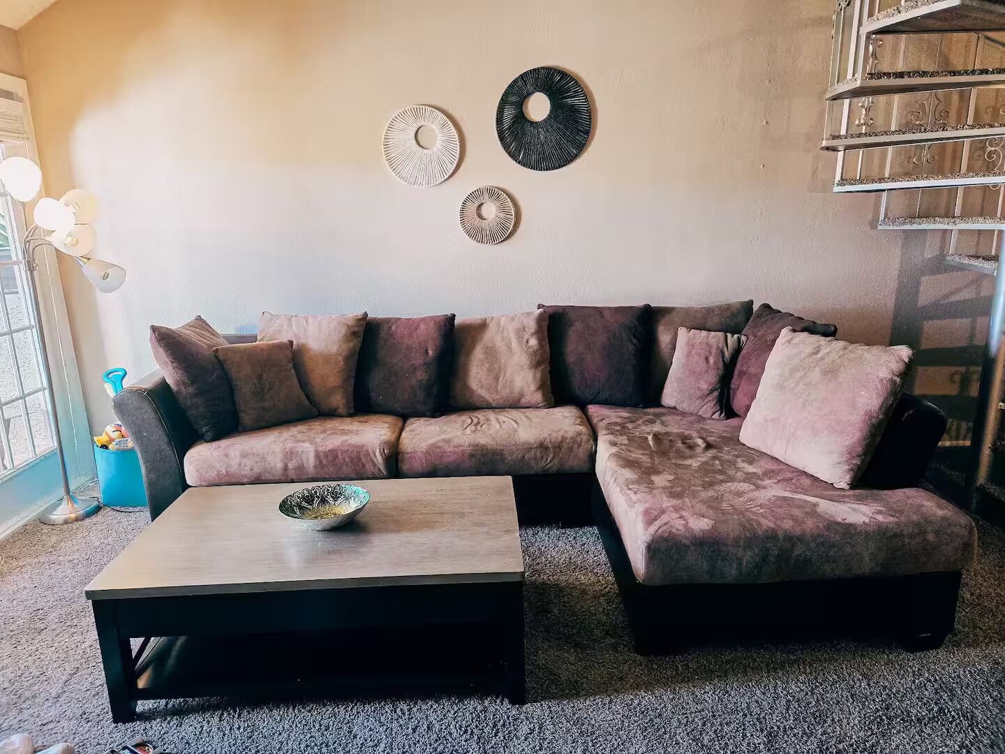 A living room with a sectional sofa, a coffee table, and decorative wall art.