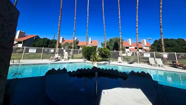 A swimming pool with a clear blue sky and tall palm trees in the background. - Home Away from Home in Mesa (Mesa)