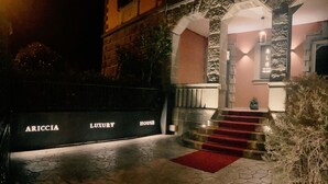 A luxury house entrance with a red carpet and stone steps. - ARICCIA LUXURY HOUSE (Ariccia)