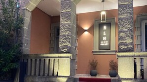 A hotel entrance with stone arches, a red carpet, and a sign above the door. - ARICCIA LUXURY HOUSE (Ariccia)