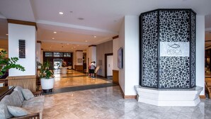 A hotel lobby with a reception desk, a seating area with a sofa, and a decorative wall with a sign reading "PESCA Waikiki Beach". - 4th Fl Ilikai | Pool | AC | Marina View (Honolulu)