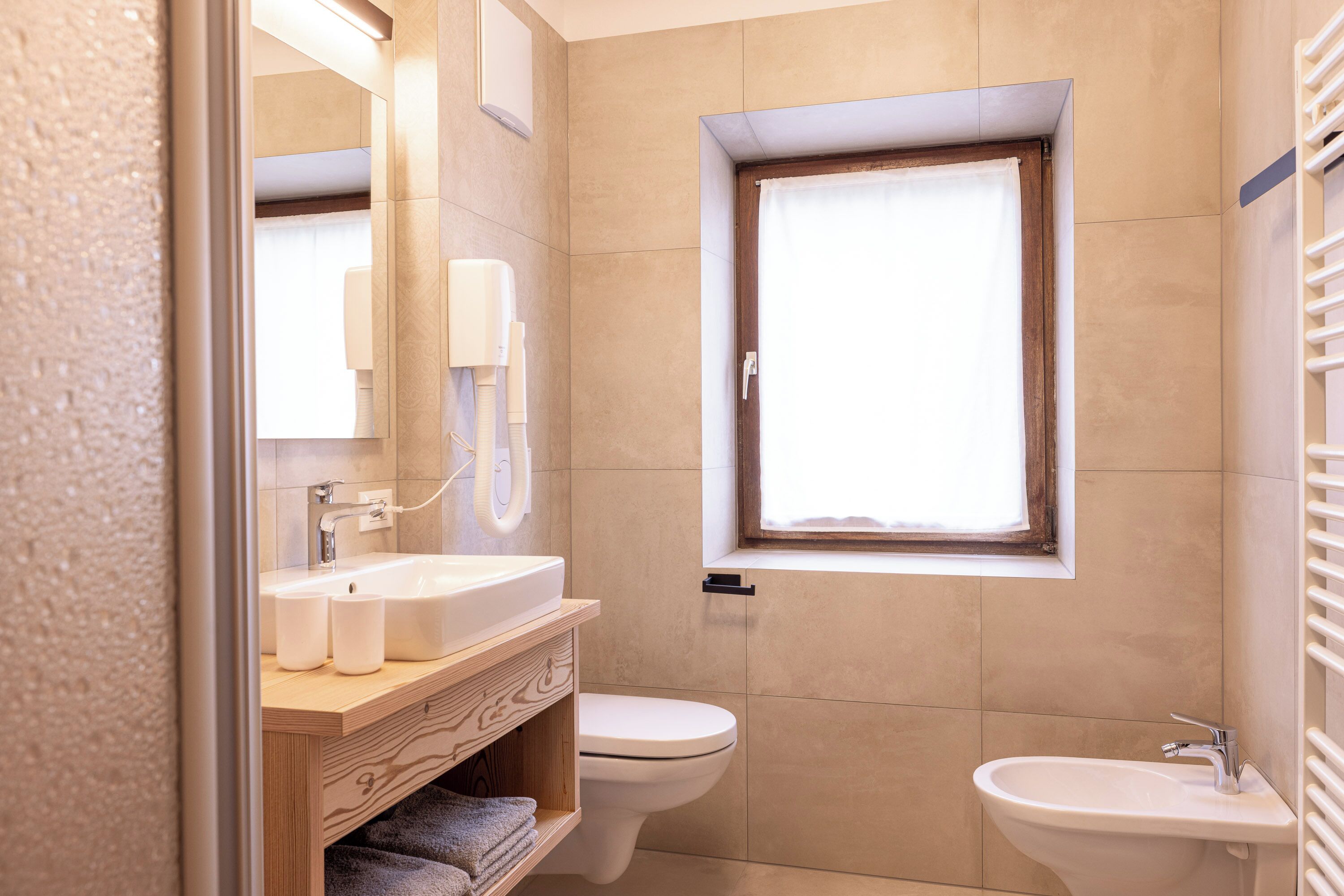 Un baño moderno con tocador de madera, inodoro y bidé.