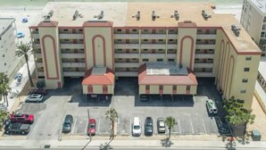 Hotel de vários andares com estacionamento e vista para a praia.