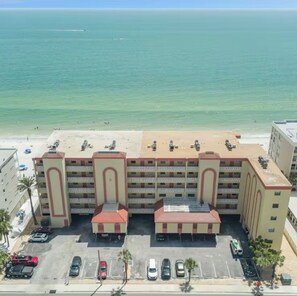A multi-story hotel with a parking lot and beach view. - ON THE BEACH! 3-bedroom condo in fabulous Madeira Beach. Amazing views. (Madeira Beach)