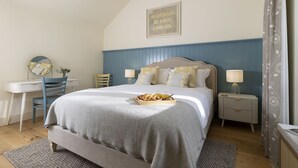A bedroom with a bed, bedside tables, a desk, and a mirror. - The Stables at Sturt Farm Courtyard - Beautiful dog friendly home in the Cotswolds with a hot tub (Burford)