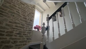 Een trap met witte balustrades en een stenen muur.
