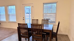 Ein Essbereich mit einem rechteckigen Tisch und sechs Holzstühlen.