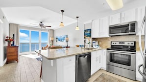 Una cocina moderna con armarios blancos, electrodomésticos de acero inoxidable y una isla grande.