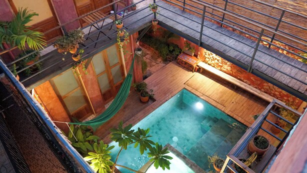 A rooftop pool area with a hammock, potted plants, and a wooden deck. - Casa Flavia @ Domus Santa Barbara Apartment with pool access in Zona Colonial (Santo Domingo)