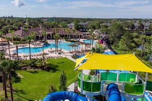 A resort with multiple swimming pools, a water slide, and a view of the surrounding area. - Windsor Hills 4BR w/ Pool, Game Room & Water Park (Kissimmee)