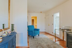 A hallway with a blue armchair, a glass coffee table, and a fireplace. - The Guest Wing at Kateri: Luxury Stay Waynesboro (Waynesboro)