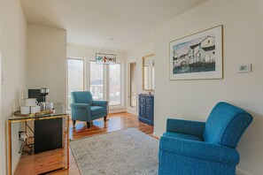 A living room with a blue armchair, a coffee table, and a framed painting on the wall. - The Guest Wing at Kateri: Luxury Stay Waynesboro (Waynesboro)