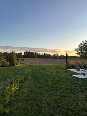 A grassy outdoor area with a clear view of a distant field and a sunset. - Charming 300m2 house in stones, can accomodate up to 12 persons. Private pool. (Pardaillan)