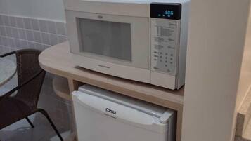 Minikjøleskap, mikrobølgeovn og høy barnestol