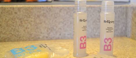 Two bottles of shampoo and two shampoo bars on a countertop.