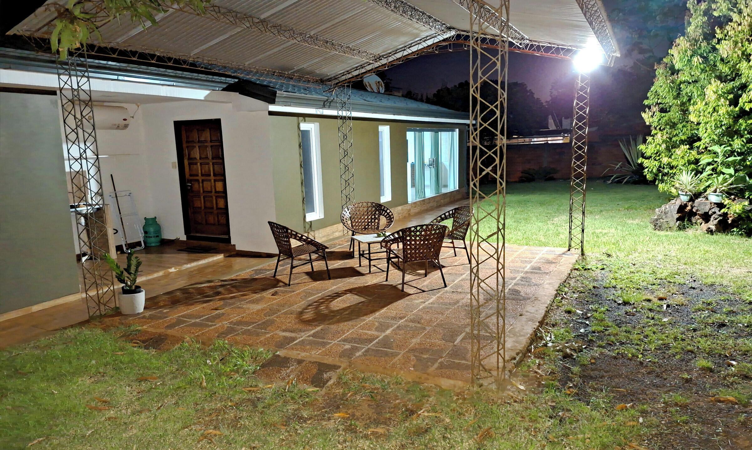 A house with a covered patio, outdoor furniture, and a garden.