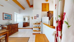 Une cuisine dotée de meubles en bois, d’un réfrigérateur et d’un coin repas avec une table et des chaises en bois.
