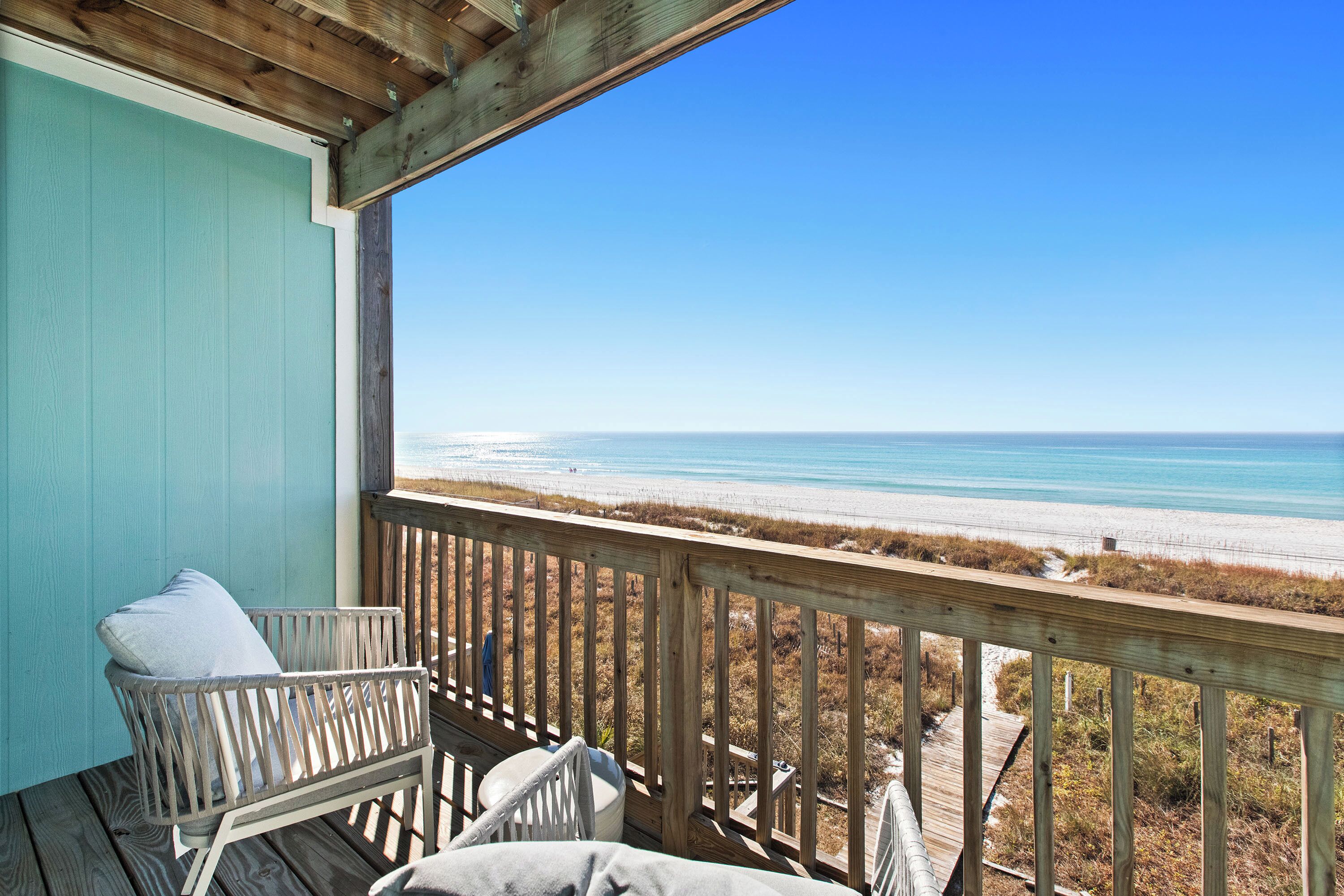 A wooden deck with a view of the beach.