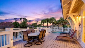 A wooden deck with a pool, outdoor seating, and a view of the sunset. - Grits-Carlton: Private beach steps away, Heated pool, Bunk rooms, Lakefront view (Miramar Beach)