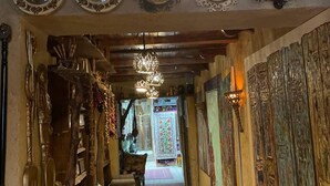 A hallway with ornate clocks, a chandelier, and traditional decor. - Old City Butik Hotel (Tashkent)
