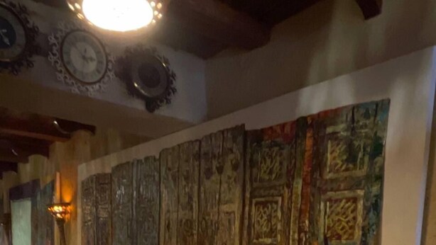 A hallway with a large abstract painting on the wall and a patterned rug on the floor. - Old City Butik Hotel (Tashkent)