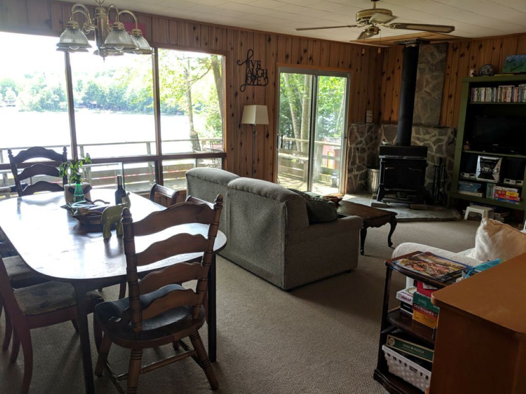 Una sala de estar acogedora con chimenea, una mesa de comedor con sillas, un sofá y una televisión.