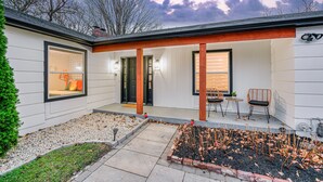 A modern house with a covered patio, a garden with gravel and plants, and a view of the sky. - Private Pickleball Court+Huge Fenced Yard, Easy Access to Grand Park & Downtown (Indianapolis)