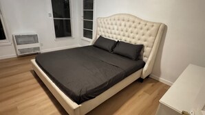 A bedroom with a large bed, white walls, and wooden flooring. - Big, Serene, Central, Perfect LA (Los Angeles)