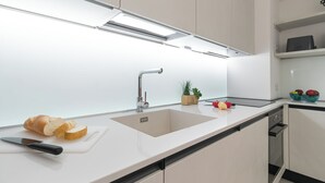 Eine moderne Küche mit Spüle, Arbeitsplatte und Schneidebrett mit Brot und Messer.