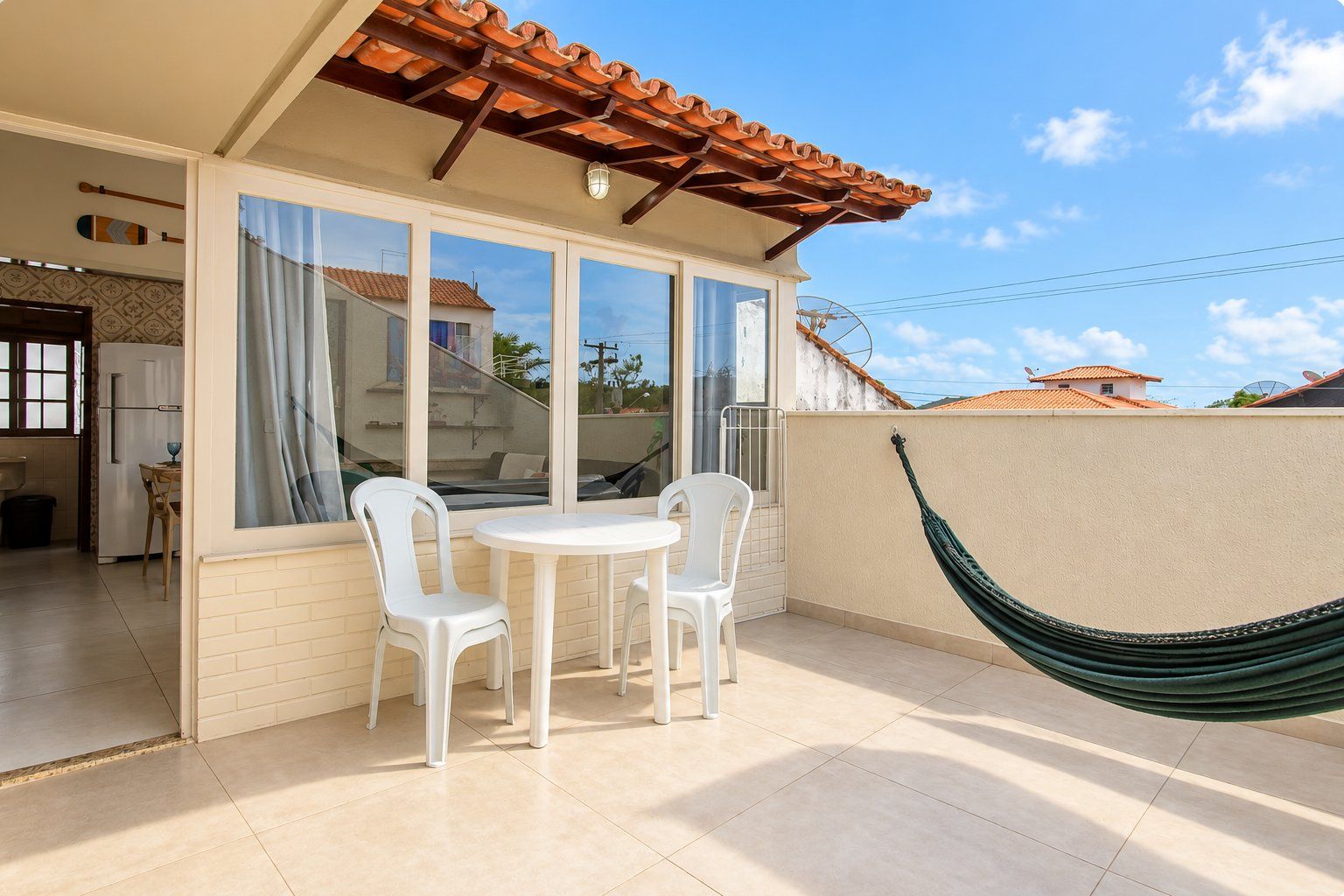 Eine Terrasse mit Tisch und Stühlen, einer Hängematte und Blick auf die Umgebung.
