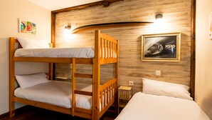 A bunk bed room with wooden walls, a framed picture, and a small bedside table. - Casa Del Surf Somo: Room 5 (Somo)