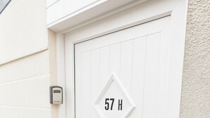 A white door with a house number sign and a doorbell. - James Lodge Rishton (Rishton)