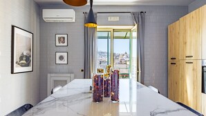 Una cocina moderna con encimera de mármol, un amplio ventanal con vistas a la ciudad y armarios de madera.