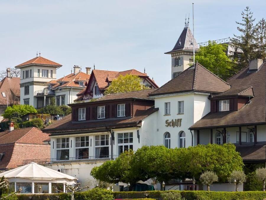 Ein traditionelles europäisches Gebäude mit einem Schild, auf dem 'Schiff' als Hinweis auf ein Hotel steht.