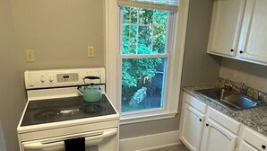 Une cuisine équipée d’une cuisinière, d’un four et d’une fenêtre.