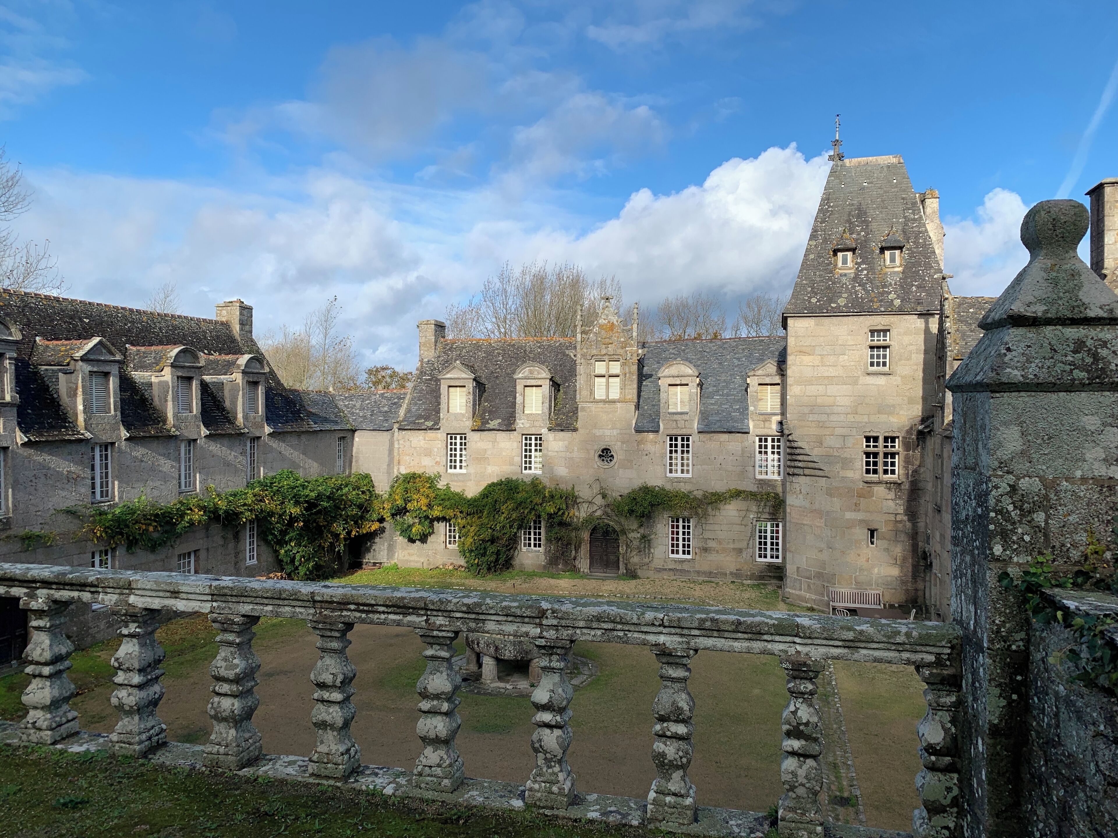 A historic stone building with multiple windows and a prominent tower.
