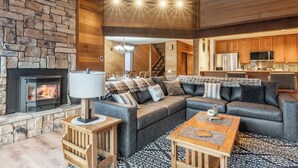 A cozy living room with a stone fireplace, a modern sofa set, and a wooden coffee table. - Hogans Hideaway  639 (Mammoth lakes)