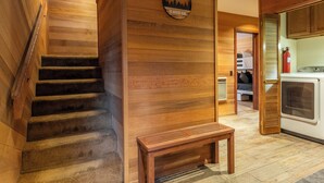 A wooden staircase leading to a bedroom with a bunk bed, a small wooden bench, and a wall-mounted circular sign. - Hogans Hideaway  639 (Mammoth lakes)