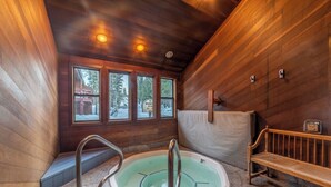 A wooden cabin with a hot tub, stone flooring, and a bench. - Hogans Hideaway  639 (Mammoth lakes)