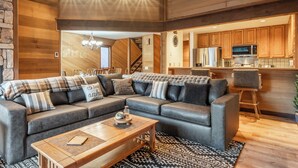A modern living room with a sectional sofa, wooden coffee table, and a patterned rug. - Hogans Hideaway  639 (Mammoth lakes)