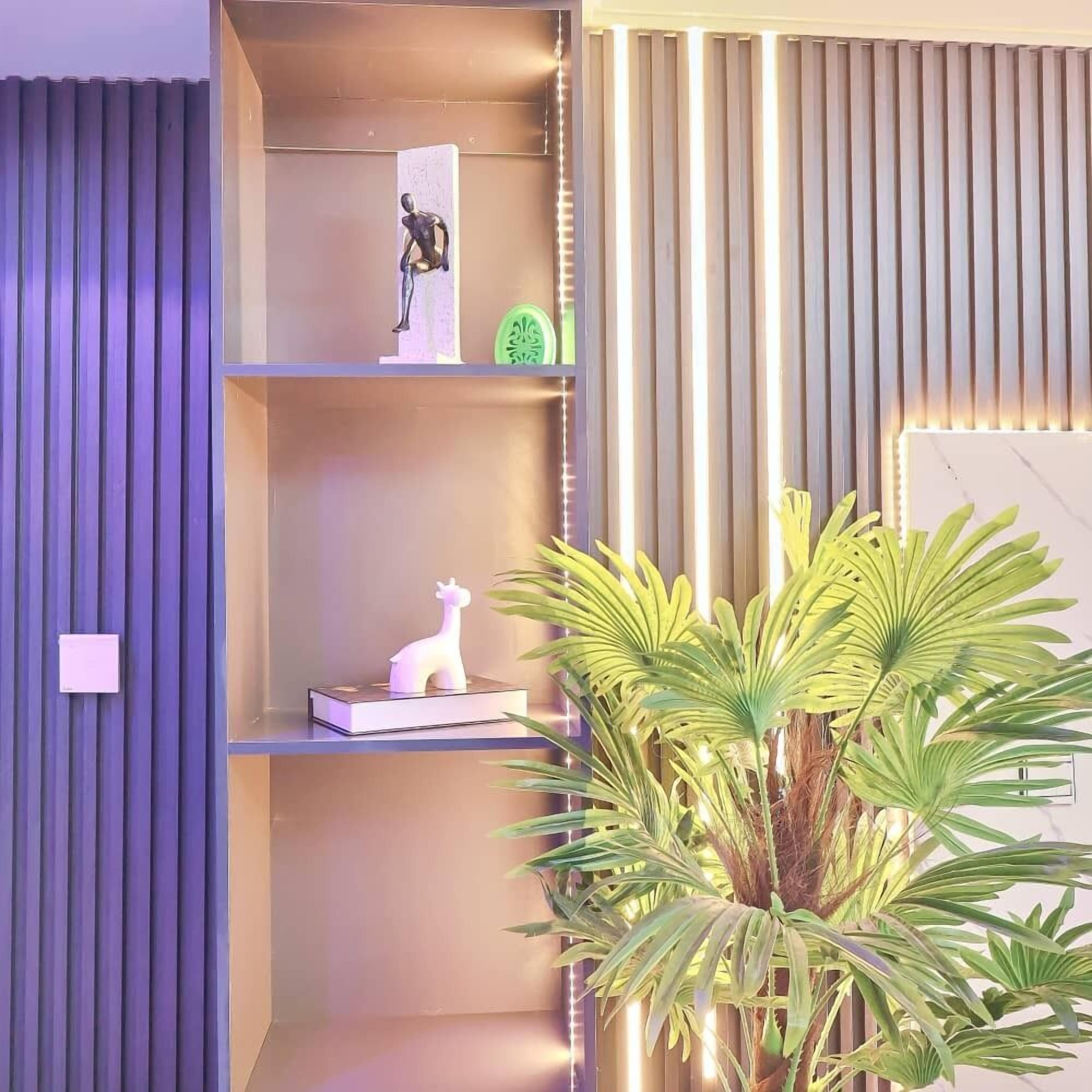 A modern interior with a built-in shelf unit, a potted plant, and a decorative giraffe figurine.
