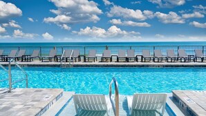 Ein Poolbereich mit Liegestühlen und Meerblick.