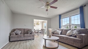 A living room with two sofas, a coffee table, and a ceiling fan. - Grey Moon Escape In Bloomington (Bloomington)
