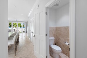 A modern bathroom with a toilet, a shower, and a large window. - Spacious 4-bedroom townhome in peaceful Palm Cay,  New Providenc, Nassau. (New Providence)