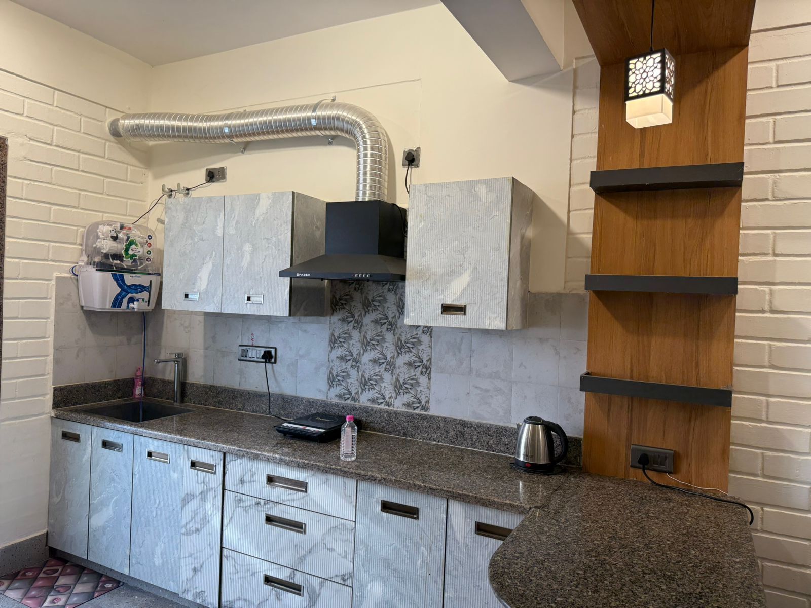 Una cocina moderna con armarios de mármol, extractor de acero inoxidable y horno empotrado.