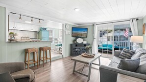 En modern inredning med kök, matplats och vardagsrum, med ett stort fönster som erbjuder en fin utsikt.