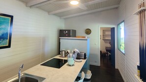 A modern kitchen with a central island, a sink, and bar stools. - Villa, lodge 6-7 pers, exceptional view, comfort and nature from the center. (Le Diamant)