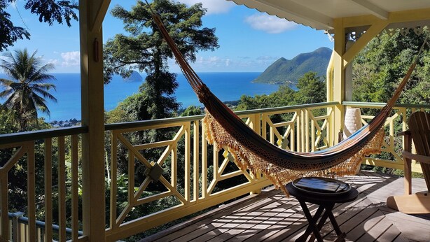 A hammock on a wooden deck with a view of the ocean and mountains. - Villa, lodge 6-7 pers, exceptional view, comfort and nature from the center. (Le Diamant)